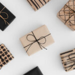 Neutral gift-wrapped boxes styled on a soft minimalist background for a quiet-luxury holiday aesthetic.