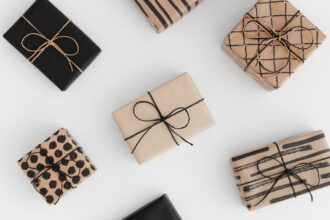 Neutral gift-wrapped boxes styled on a soft minimalist background for a quiet-luxury holiday aesthetic.